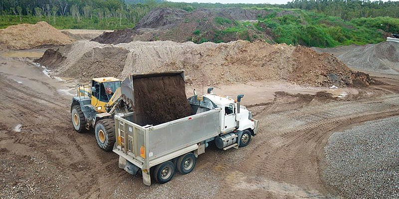 loader truck loading premium soil into tipper truck